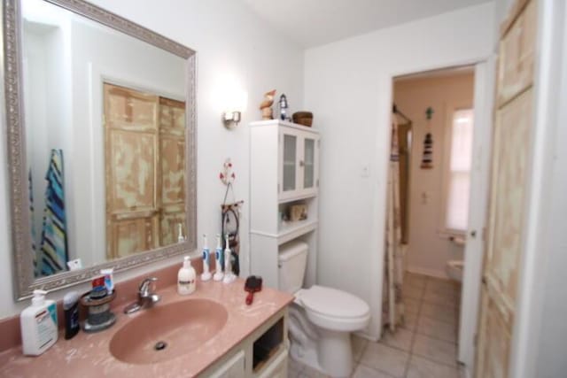 bathroom with toilet, tile patterned flooring, and vanity