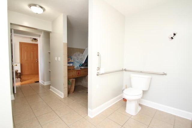 bathroom featuring toilet, baseboards, and tile patterned floors