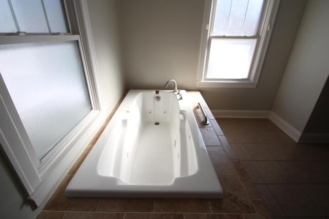 bathroom with baseboards, a whirlpool tub, and tile patterned floors