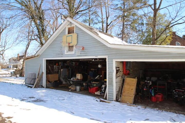 snow covered garage with a detached garage