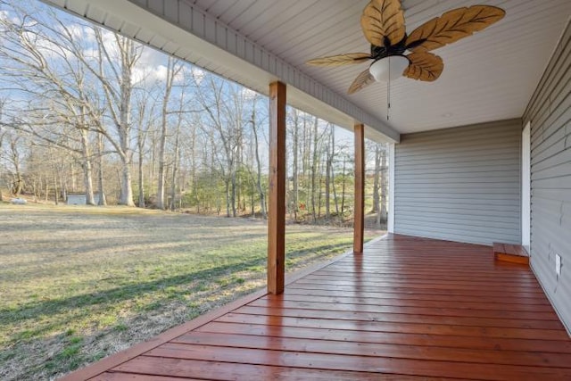 wooden deck featuring a lawn and a ceiling fan