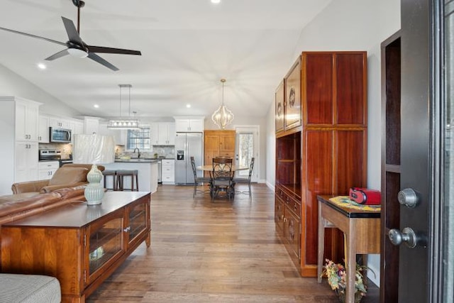 interior space with lofted ceiling, a ceiling fan, wood finished floors, and recessed lighting