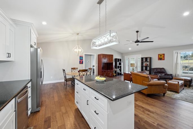 kitchen with lofted ceiling, appliances with stainless steel finishes, dark wood-type flooring, white cabinetry, and a kitchen island