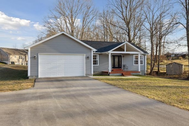 view of front of property featuring a garage, driveway, a porch, and a front yard