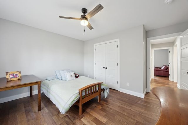 bedroom with a closet, ceiling fan, baseboards, and wood finished floors