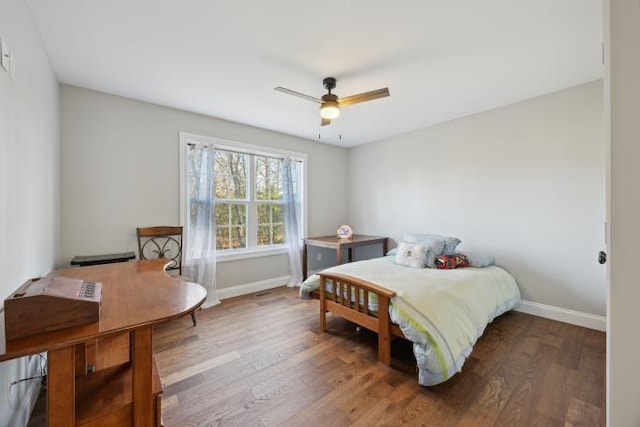 bedroom with ceiling fan, baseboards, and wood finished floors