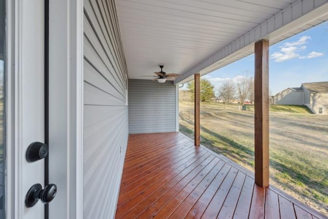 wooden terrace featuring a lawn and ceiling fan