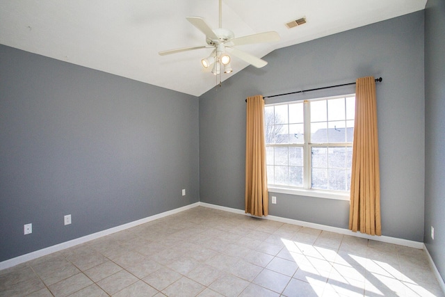 empty room featuring lofted ceiling, light tile patterned floors, and ceiling fan