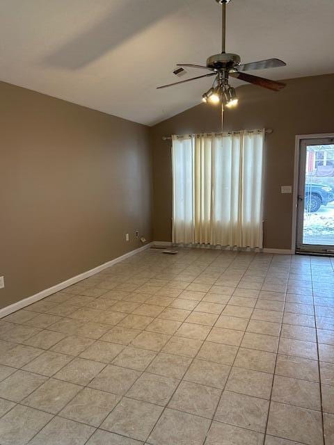 tiled empty room featuring lofted ceiling and ceiling fan