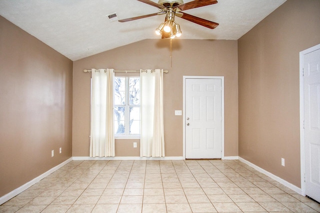 tiled empty room featuring vaulted ceiling and ceiling fan