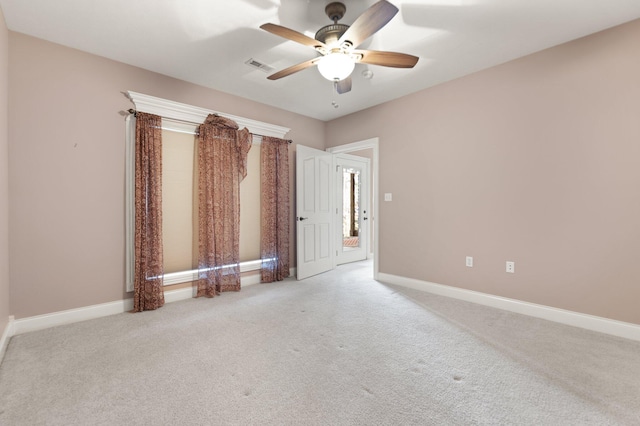 carpeted spare room with ceiling fan