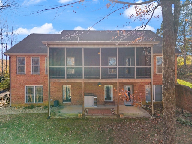 rear view of house with a patio, central AC, a yard, and a sunroom