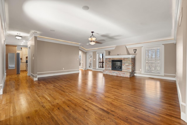 unfurnished living room featuring ceiling fan, wood-type flooring, and crown molding