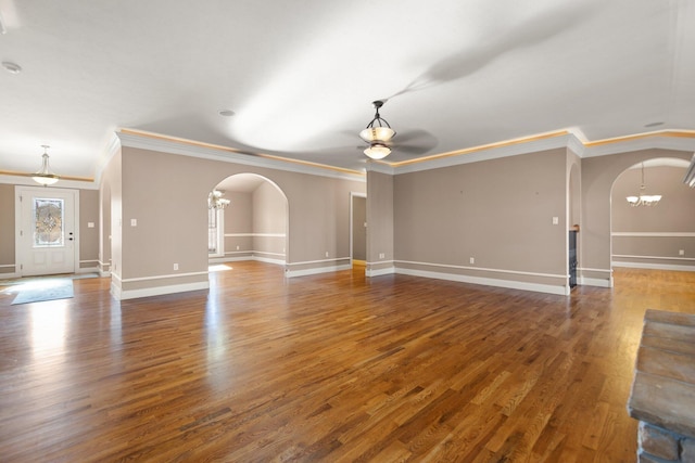 unfurnished living room with a chandelier, crown molding, and dark hardwood / wood-style flooring