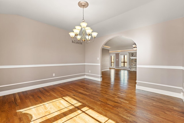 spare room with hardwood / wood-style flooring and an inviting chandelier