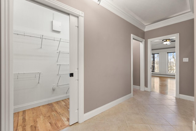 hallway with ornamental molding and light tile patterned flooring