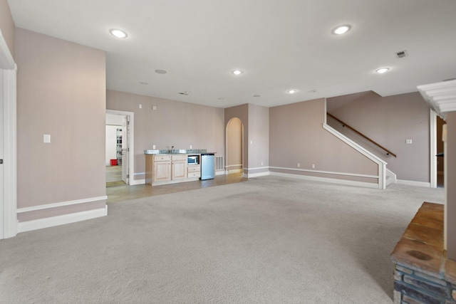 unfurnished living room featuring sink and light colored carpet