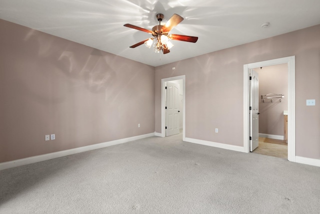 unfurnished bedroom with a closet, ceiling fan, light colored carpet, and a spacious closet