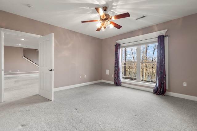 spare room featuring ceiling fan and light carpet