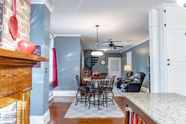 dining room featuring ceiling fan, baseboard heating, dark hardwood / wood-style flooring, and crown molding