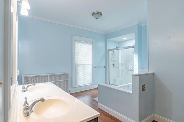 bathroom with vanity, ornamental molding, a shower with door, and wood-type flooring