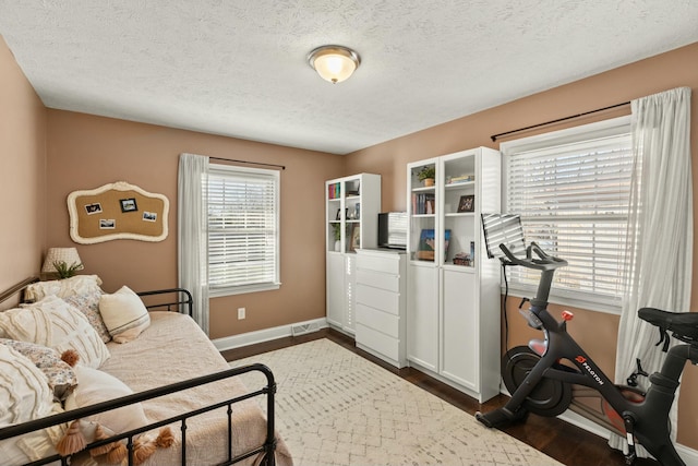 bedroom with dark wood-type flooring and a textured ceiling