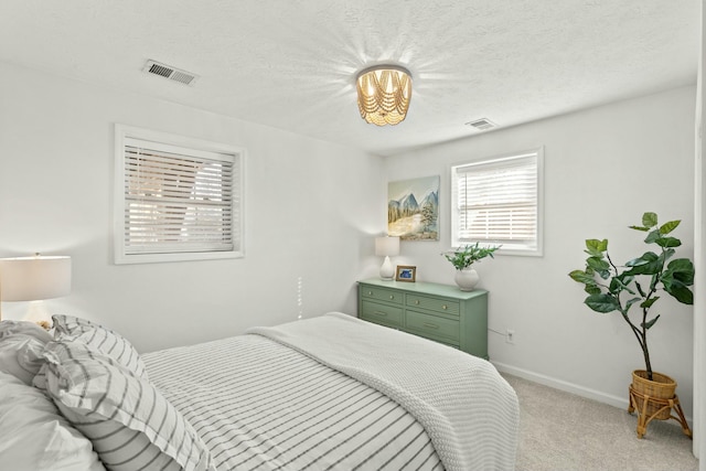 bedroom with light carpet and a textured ceiling