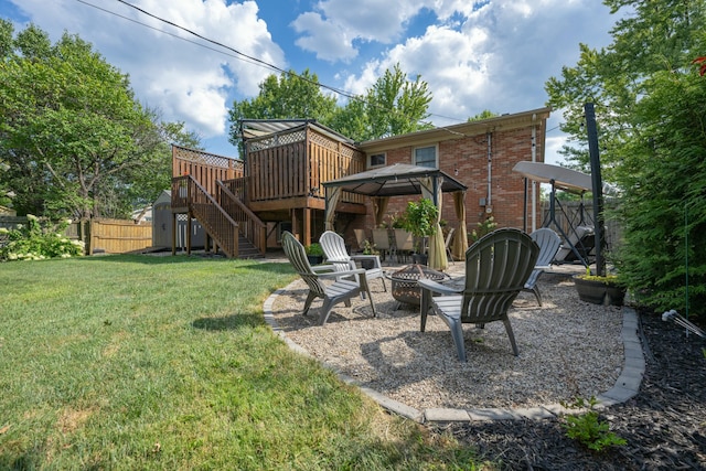 back of house with a fire pit, a lawn, a deck, and a gazebo