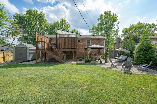 back of property featuring a storage shed, a fire pit, a deck, a gazebo, and a patio