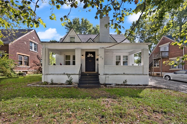 view of front of home with a porch and a front lawn