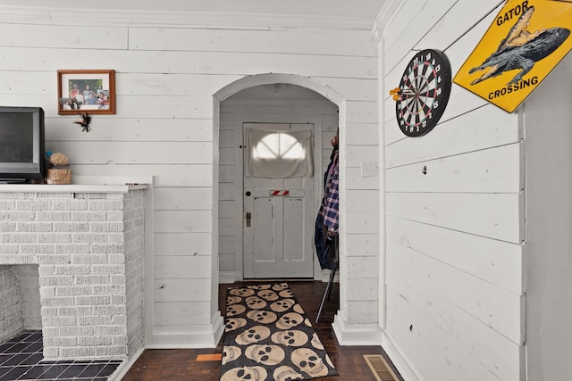 entrance foyer featuring crown molding, dark hardwood / wood-style floors, and wood walls