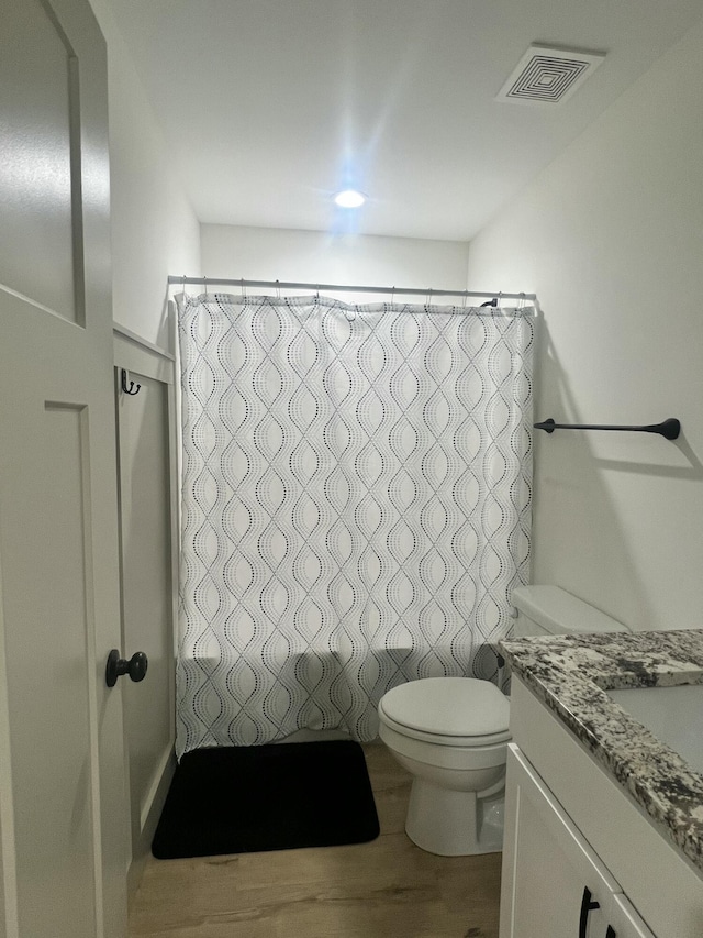 bathroom with vanity, hardwood / wood-style floors, and toilet