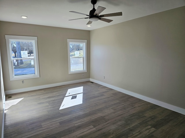 unfurnished room featuring dark wood-style floors, ceiling fan, and baseboards