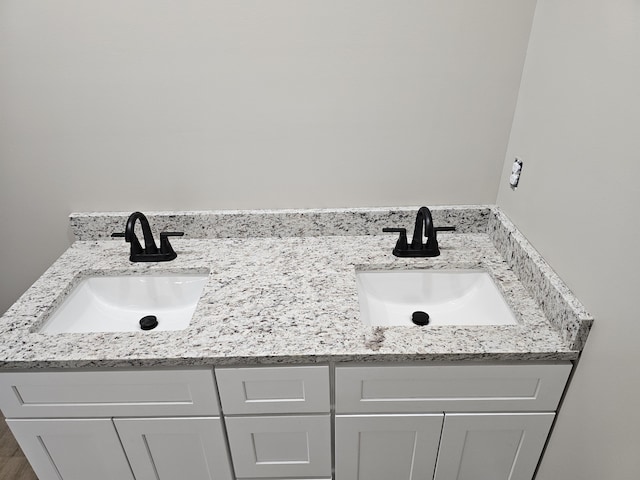 full bathroom with a sink and double vanity