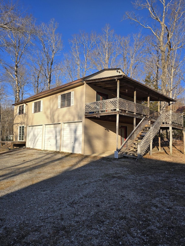 rear view of house with a garage and a deck