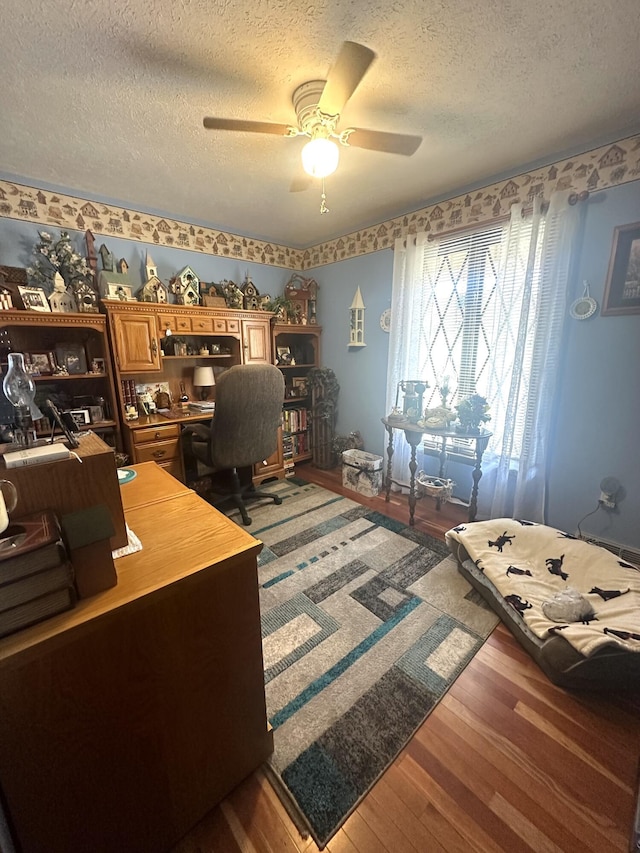 office space featuring hardwood / wood-style flooring, ceiling fan, and a textured ceiling