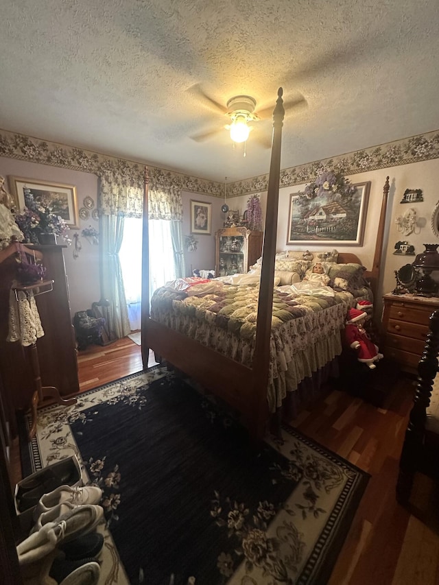 bedroom with ceiling fan, wood-type flooring, and a textured ceiling