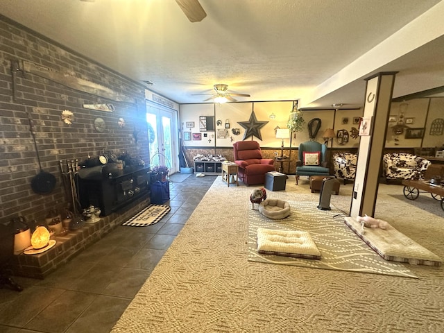 tiled living room with ceiling fan and a textured ceiling