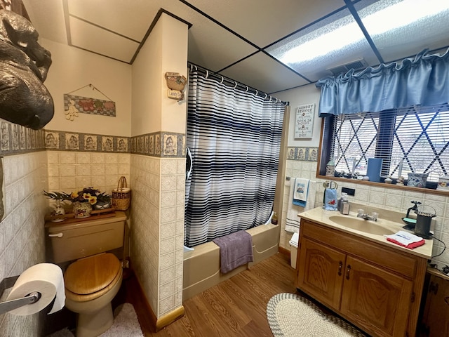 full bathroom with shower / bath combination with curtain, toilet, tile walls, and hardwood / wood-style flooring