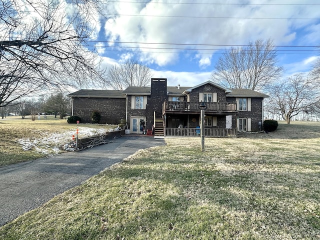 view of front of property with a deck and a front lawn