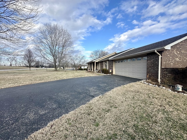 view of side of property featuring a garage and a yard