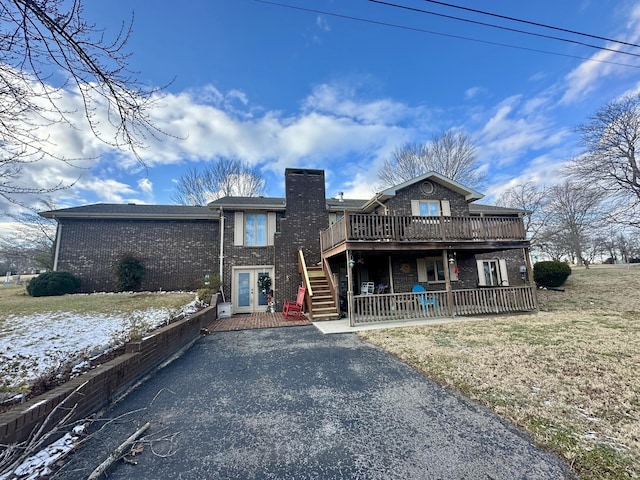 view of front of home with a wooden deck and a front yard