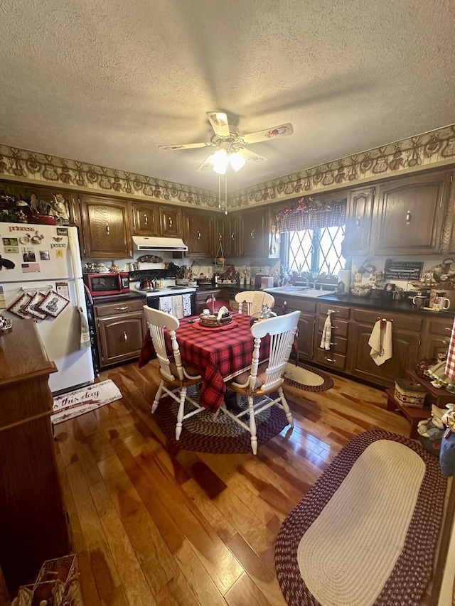 dining area featuring hardwood / wood-style floors, a textured ceiling, and ceiling fan