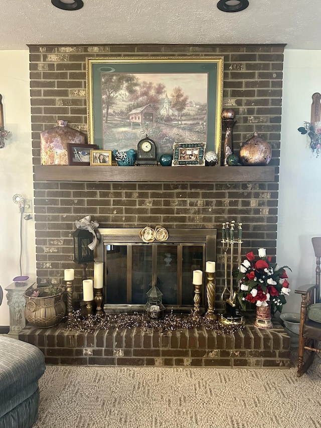 interior details featuring a brick fireplace and a textured ceiling