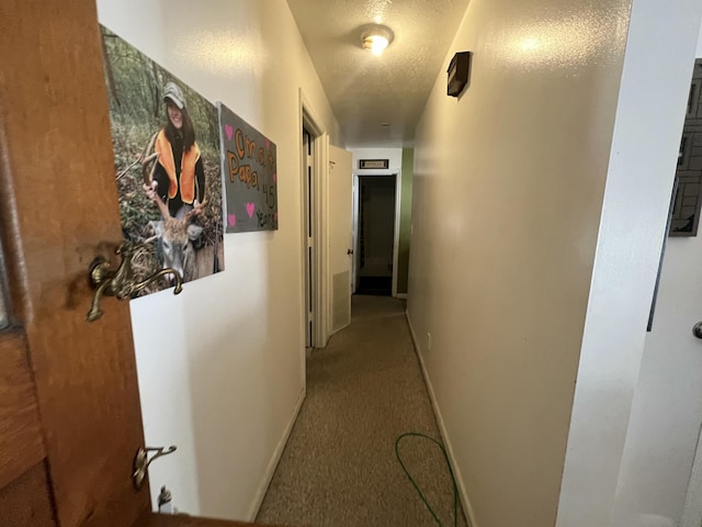 corridor featuring carpet floors and a textured ceiling