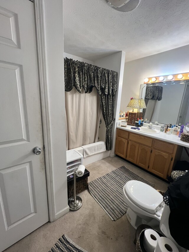 bathroom featuring a textured ceiling, toilet, and vanity