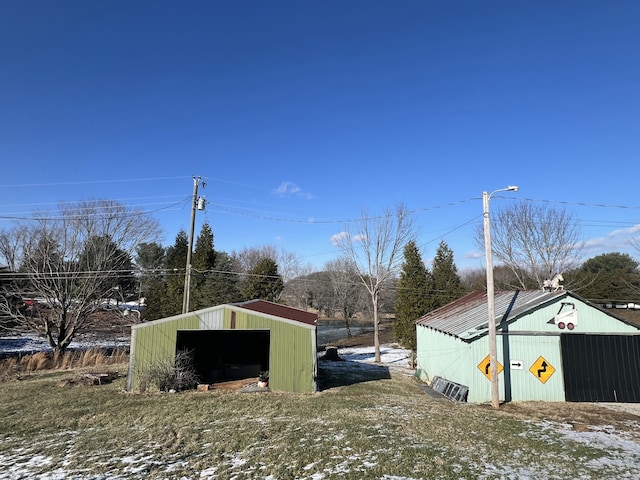 view of yard featuring a garage and an outbuilding