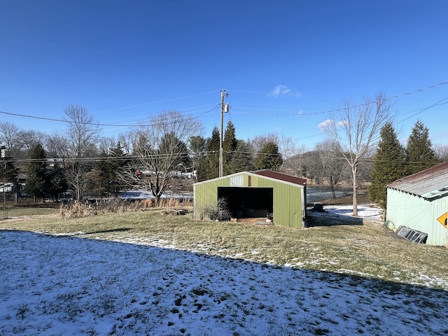 snowy yard with an outbuilding and a garage