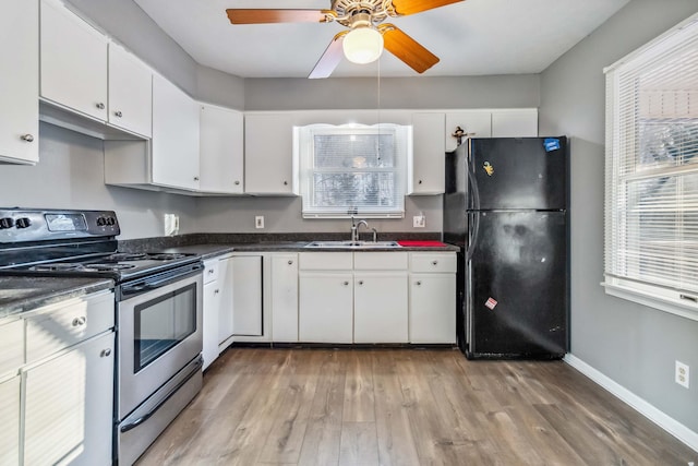 kitchen with black refrigerator, white cabinetry, sink, light hardwood / wood-style flooring, and stainless steel electric stove