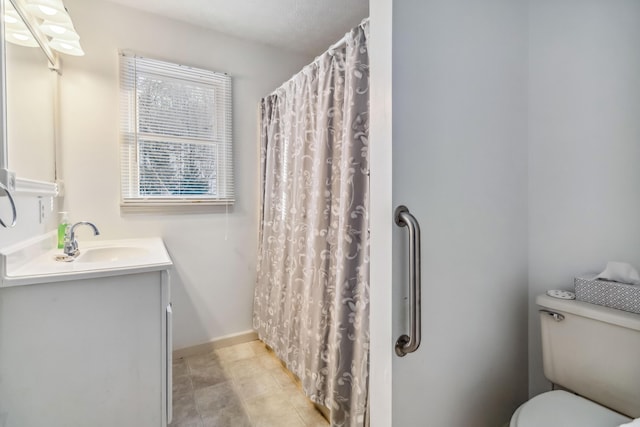 bathroom featuring toilet, vanity, and a shower with curtain